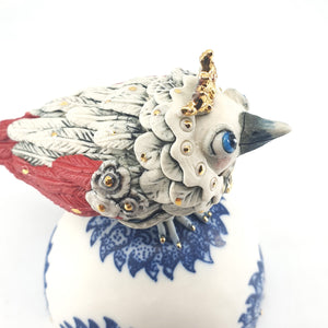 Baby Bird with red wings and tail on blue floral stand